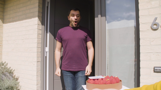 Een stralende Thomas neemt de Bake Off-taart met veel plezier in ontvangst